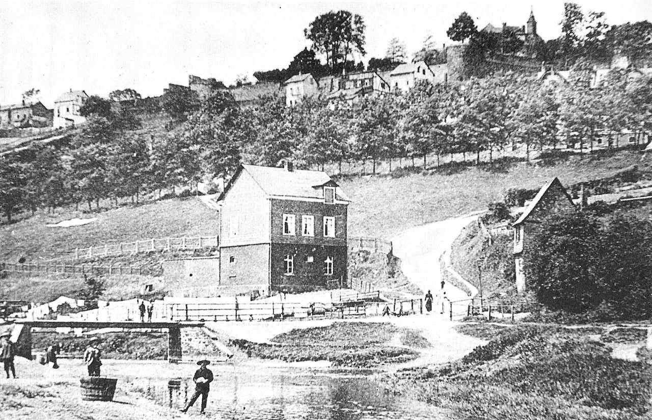 Hain im Jahr 1909. Im Vordergrund der Fluss Weiß, oben rechts auf dem Siegberg das Obere Schloss Siegens. (Bild aus Hain Siegen - Wikipedia)